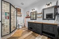 Primary bath with large tile shower and double free-standing sinks