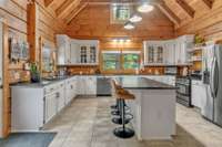 Renovated kitchen with granite countertops, white cabinets, and stainless steel appliances.