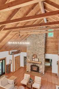 Soaring vaulted ceilings with updated lighting showcasing the floor to ceiling stone fireplace.