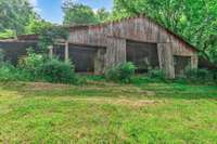Huge barn near the front of the property will need to be restored or demoed but sits on spacious level acreage.