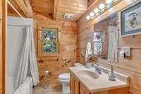 Full bathroom with shower/tub combo and tiled floors.