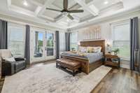 The primary suite features stunning coffered ceilings, lhardwoods, and a ceiling fan, with natural light streaming in through multiple windows. 8385 Lascassas Pike Lascassas, TN 37085
