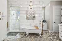 A beautiful clawfoot soaking tub sits beneath a stunning chandelier, creating a spa-like atmosphere. 8385 Lascassas Pike Lascassas, TN 37085