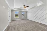 The stunning primary bedroom with accent wall and en suite bathroom