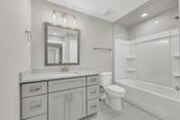 Hall Bathroom with granite countertops and tile surround