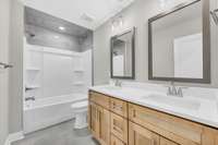 Second full bath with double vanities and tile surround