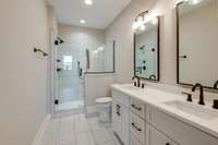 Modern and minimalist—this all-white bathroom features striking dark fixtures for a clean, contemporary look