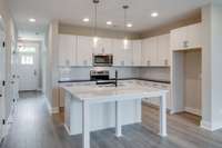 Bright, open-concept kitchen with a spacious island table that can seat five—perfect for casual dining and effortless entertaining.