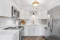 Stainless steel appliances include refrigerator, dishwasher range, and microwave