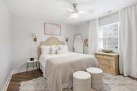 Primary bedroom with ceiling fan, blinds, and decorative curtains