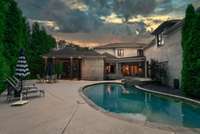 From behind the pool, take in the breathtaking view of the home’s grand architecture and expansive outdoor living spaces — a striking backdrop that perfectly complements the resort-style setting.