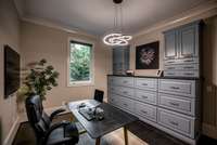 A dedicated office space thoughtfully designed with abundant built-in cabinetry and storage, offering a functional and stylish environment perfect for working from home or managing household needs.
