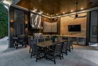 An exceptional outdoor dining and entertaining area, fully equipped with an oversized gas grill, ample countertops, refrigerators, and a sink — all thoughtfully covered with ceiling fans to create a luxurious space for gatherings in any season.