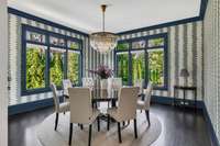 A true statement room, the formal dining space captivates with bold accent wallpaper and expansive picture windows on two walls, flooding the room with natural light and creating an unforgettable setting for gatherings.