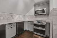 An upstairs kitchenette complete with its own stove, microwave, and generous prep space — perfect for entertaining, multi-generational living, or creating a convenient guest suite experience.