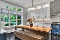 Bathed in natural light, the inviting kitchen dining area offers the perfect setting for casual meals or morning coffee, framed by expansive windows that bring the outdoors in.