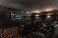 A dedicated theatre room designed for the ultimate cinematic experience, featuring authentic movie-theater seating and a dark, immersive ambiance perfect for enjoying films in true luxury.