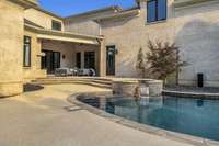 The spacious back patio seamlessly transitions into the pool area, offering both covered and open-air spaces ideal for effortless entertaining and enjoying the best of indoor-outdoor living.
