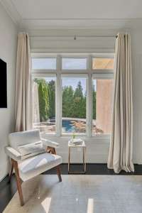 Through the expansive master windows, enjoy a breathtaking view of the sparkling pool and meticulously landscaped backyard — a resort-like scene that brings luxury right to your private suite.