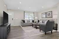 The spacious living room with visible sightlines to the kitchen and dining room.
