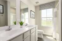 The guest bathroom includes a double bowl vanity, luxury vinyl plank flooring, and a tub/shower combo.