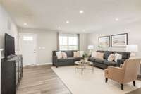 The spacious living room with visible sightlines to the kitchen and dining room.