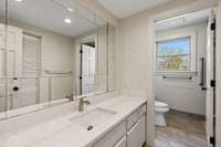 A third bath is across the hall. This one boasts an extra wide vanity and a vintage mirror!