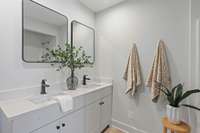 The attached bath features a modern double vanity with storage underneath.