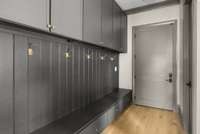 Stylish gray drop zone with gold hooks and ample upper and lower storage—where function meets everyday elegance just off the conditioned and lofted garage that allows entry for larger vehicles.