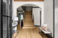 Welcoming front foyer with an elegant staircase and arched entry that set the tone for the rest of the home—bright, inviting, and thoughtfully designed.