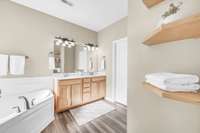 The primary bathroom includes double vanities, soaking tub, separate shower, & walk in closet.