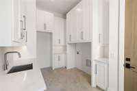 Oversized laundry room with abundant cabinetry.