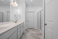 Large primary bath with double vanities, large shower and linen closet.