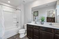The owner's en-suite features durable luxury vinyl plank flooring, an option for a double bowl vanity with ample storage, and a relaxing tub/show combination.