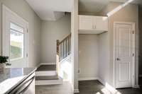 Stainless Steel Refrigerator has been installed between stairs and pantry door.
