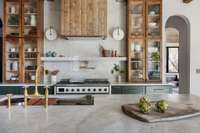 The kitchen boasts a 48” ILVE gas stove with double oven, a dedicated coffee station with pot filler, a 48” Ruvati sink, and endless countertops, cabinets, and cupboards.