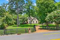 Lush emerald green grass framed by classic 4 wood plank-fencing that adds charm and privacy.