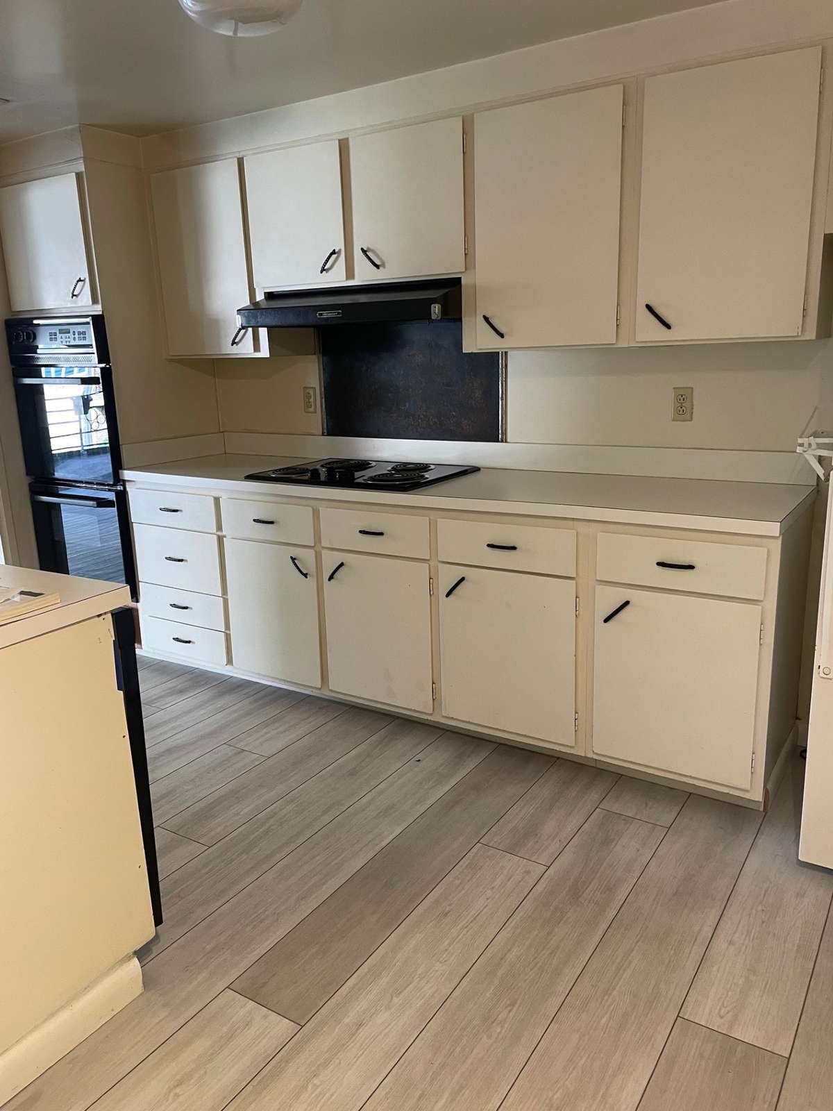 Laminate flooring - lots of space for updated cabinetry with a new look.