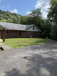 Paved drive behind the home and a view of the back