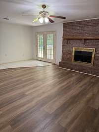 Den with wood burning fireplace with gas logs