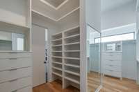 Huge primary closet with dual sides each with built-in drawers and shoe racks; leads directly into the laundry room