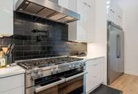 The Miele gas range includes a pot filler and a commercial-grade vent hood, ensuring ease and efficiency for the home chef