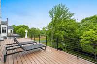 Overlooking the backyard, the private upper deck offers a serene space to relax and enjoy the outdoors.