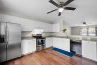 Wide-angle view of a functional, no-nonsense kitchen with granite countertops, stainless steel appliances, and loads of cabinet space.