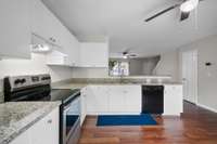 This efficient L-shaped kitchen makes the most of its footprint, with granite countertops on both sides and tons of storage above and below. The open passthrough keeps the space connected to the living area without sacrificing function.