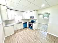 Beautifully renovated kitchen featuring new cabinets, countertops, stainless appliances, and space for an island for bar seating or intimate dining setup