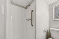 Walk in shower has a grab bar