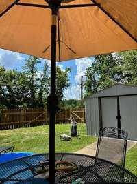 Fenced side yard with small patio and storage building