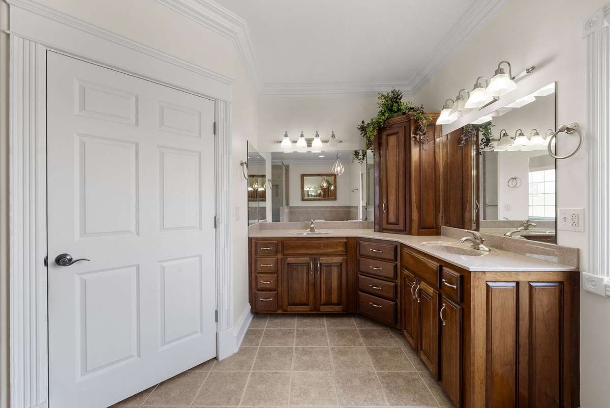 Primary bathroom with tons of cabinets, double sinks and tile flooring