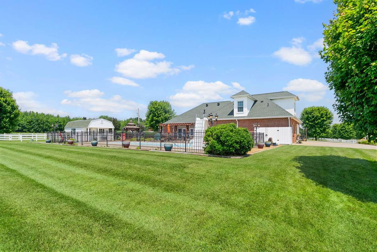 Rear view of home with beautifully well-kept lawn
